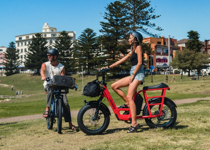 Two people with electric bikes in a park