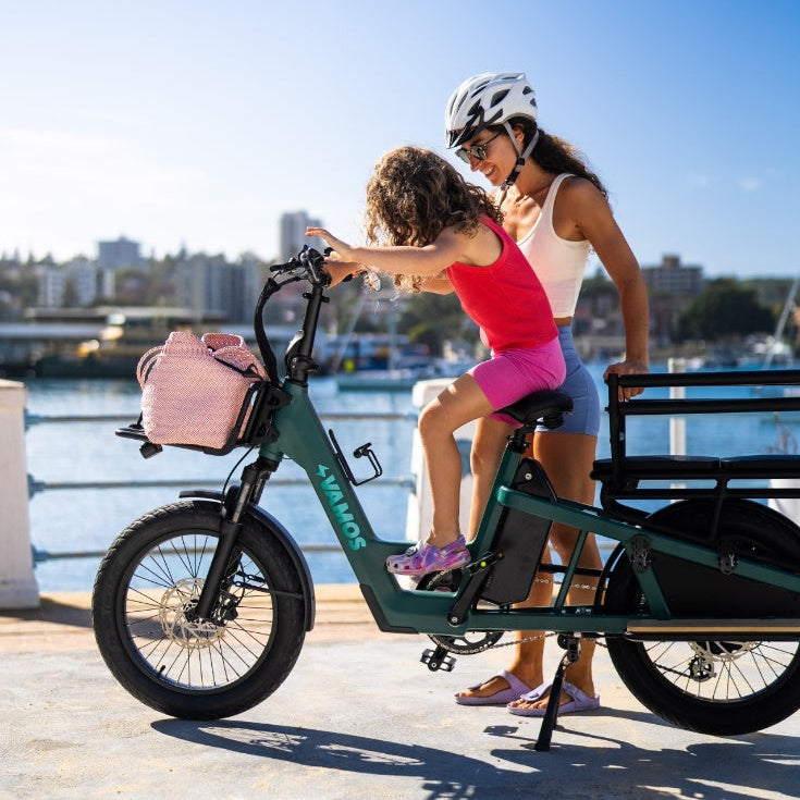 A mother wearing a helmet guides her daughter on riding the Vamos El Amigo Plus Ebike