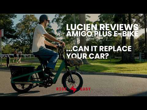 Man wearing a helmet riding a green Vamos El Amigo Plus Commuter Ebike on a paved park path